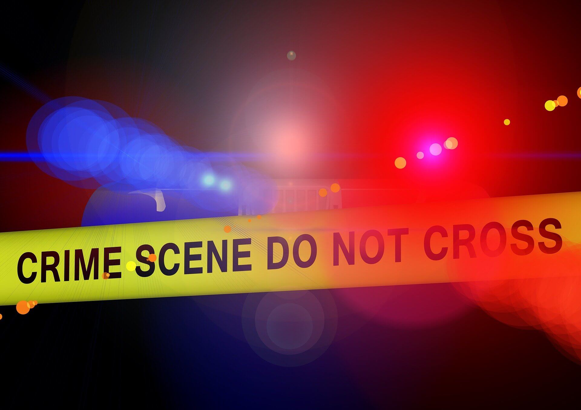 police lights behind crime scene tape